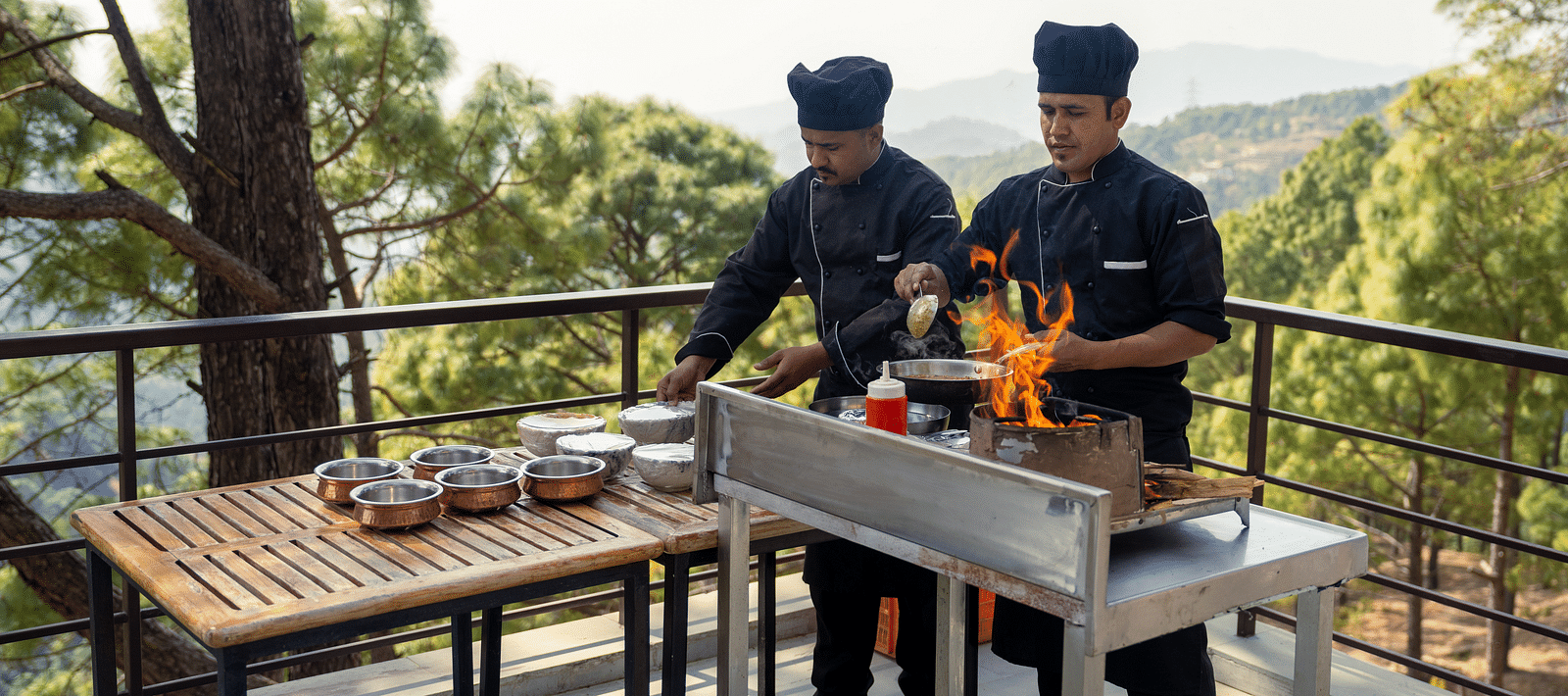 Two chefs cooking on a terrace at BluSalzz Escapade Resort, Lansdowne
