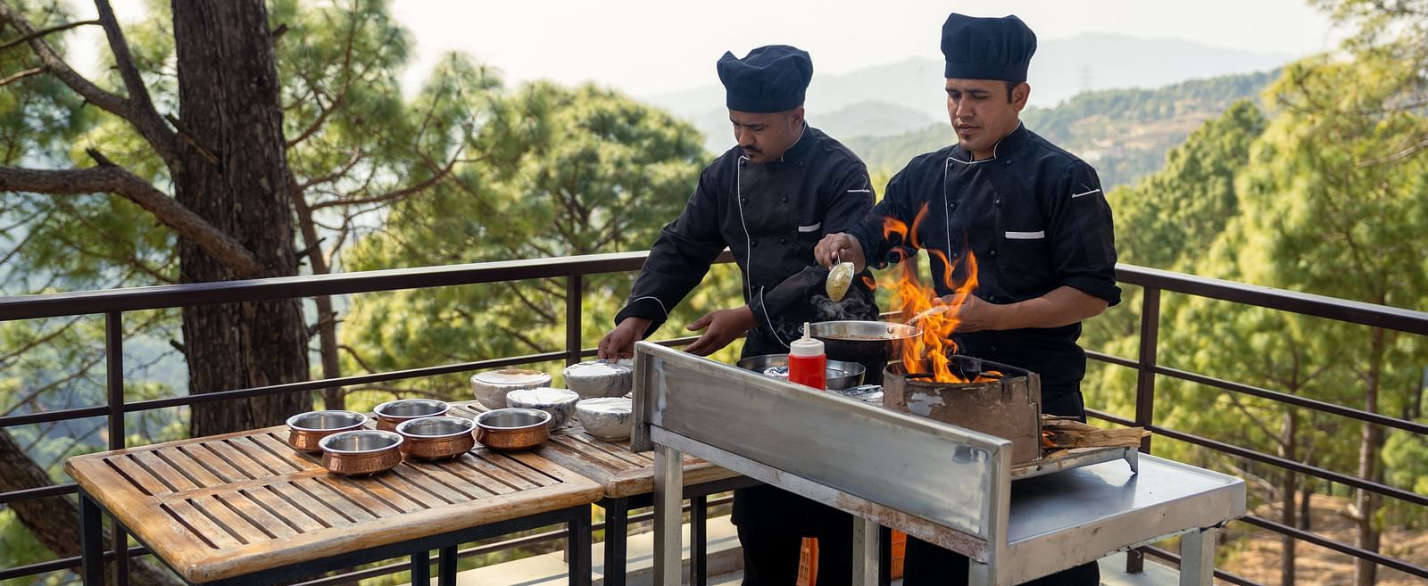 Two chefs cooking on a terrace at BluSalzz Escapade Resort, Lansdowne