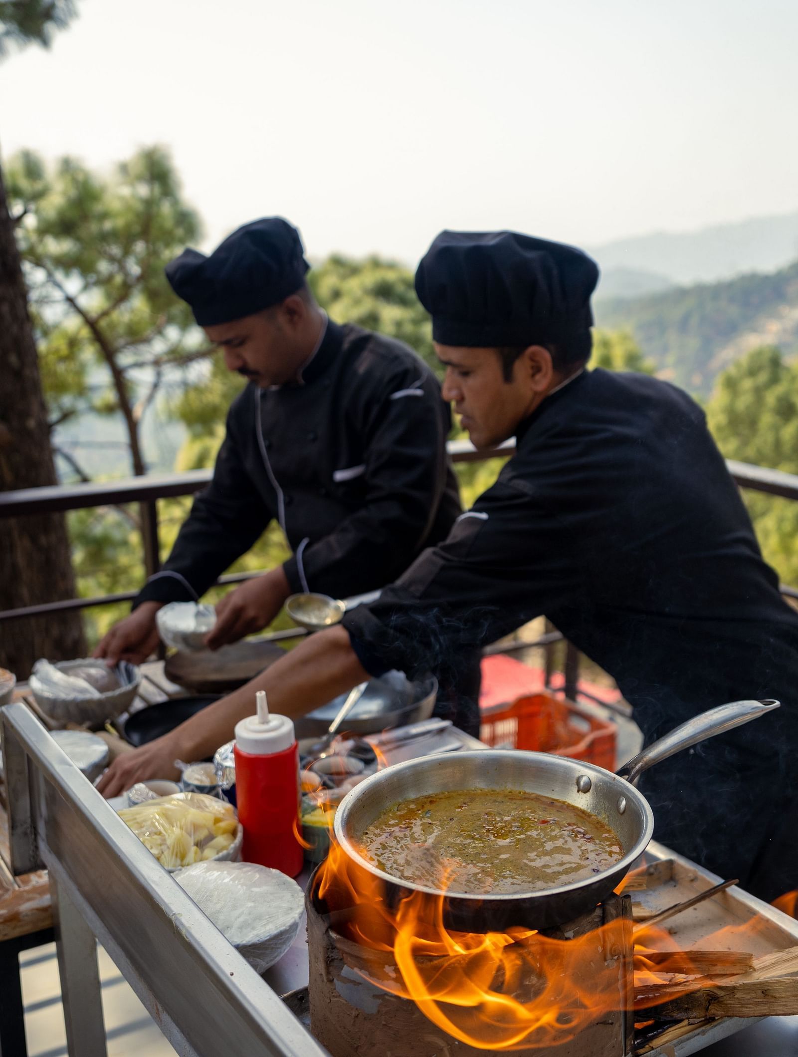 Two persons grilling food on a terrace at BluSalzz Escapade Resort, Lansdowne
