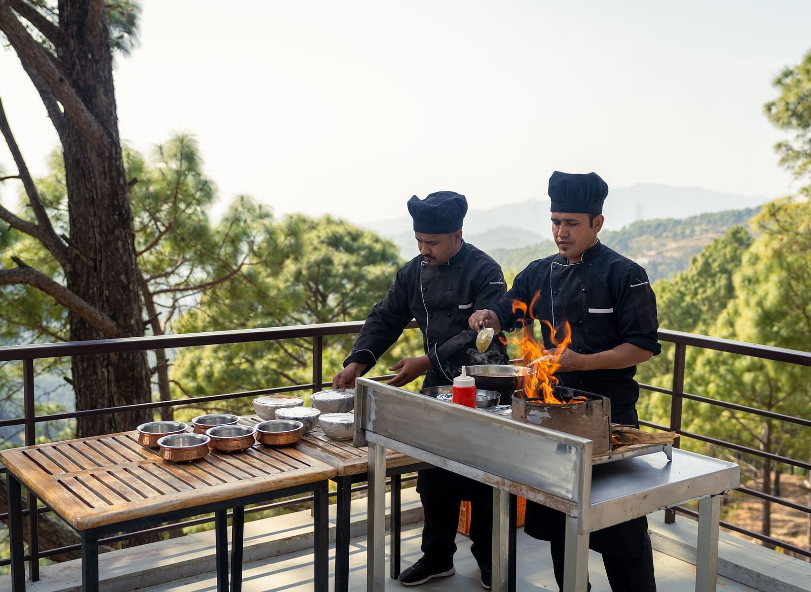 Two chefs cooking on a terrace at BluSalzz Escapade Resort, Lansdowne