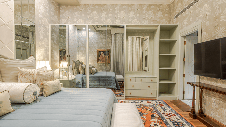 image of the bedroom from the side angle with a full length mirror attached to the spacious closet at our heritage luxury suite - The Claridges New Delhi