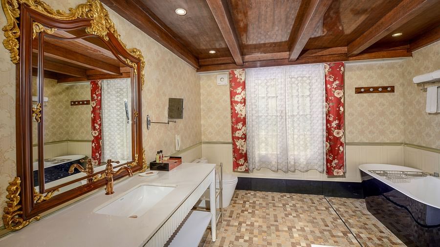 a bathroom offering a white-coloured bathtub on the right side and the washbasin on the left - Mayfair Himalayan Spa Resort Kalimpong