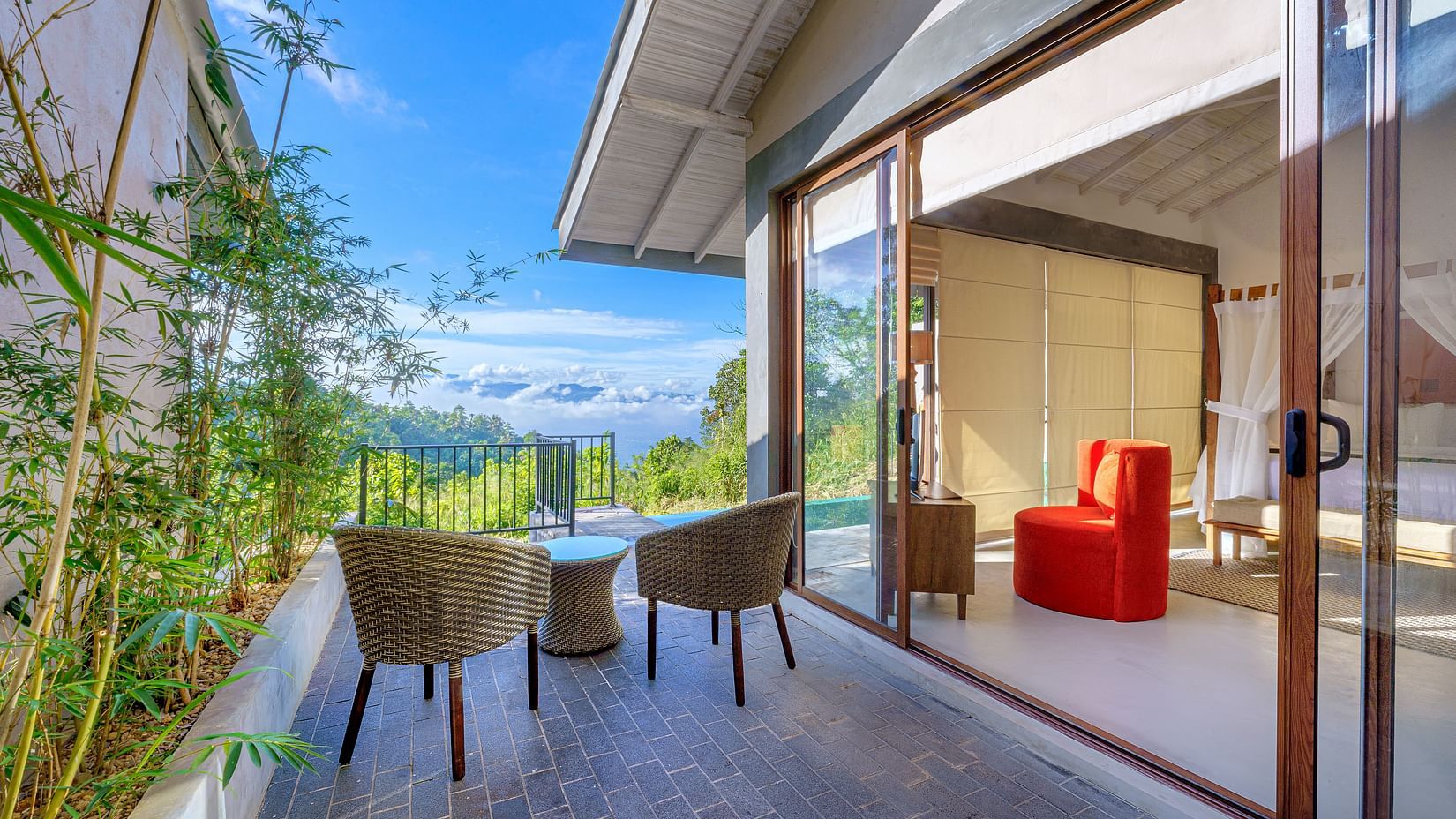 Two chairs and a jute stool placed in a balcony with a view | Celestial Hills, Villas & Suites, Kandy