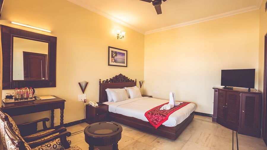 Standard Room at Paradise Isle Beach Resort, Udupi with a double bed and a work desk and chair