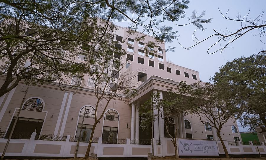 alt-text exterior facade of Hotel Polo Towers Agartala with trees covering the front side