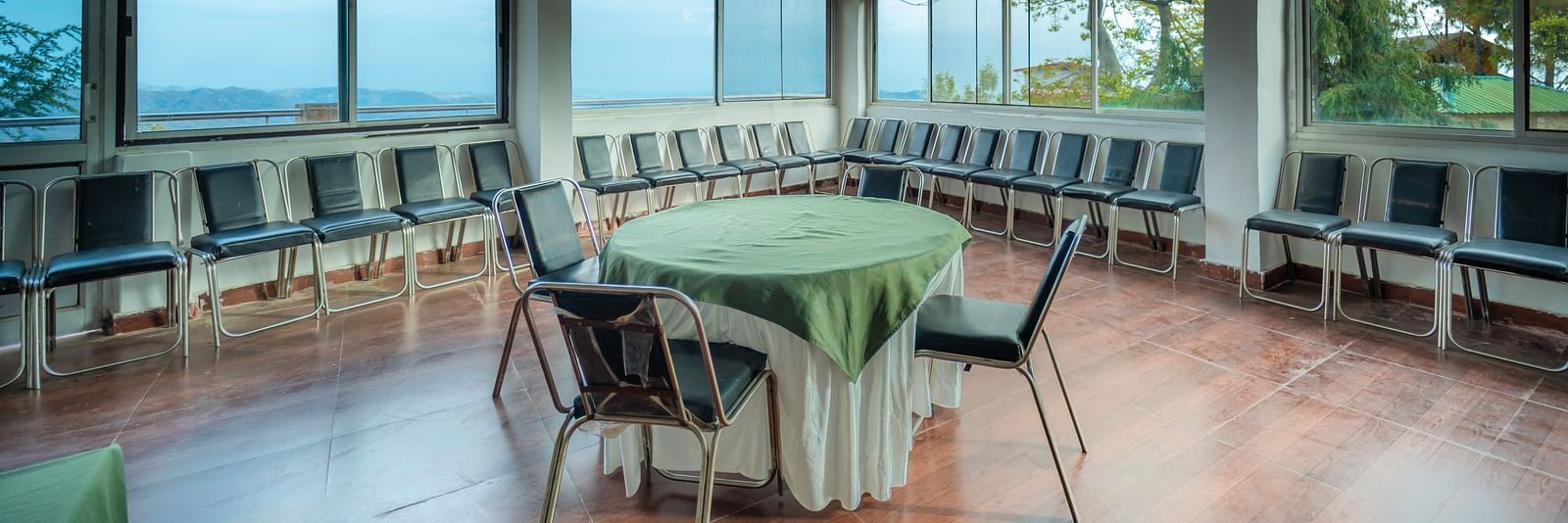 tables and chairs placed in the event venue at Flutter Hotels & Resorts surrounded by beautiful view of the valleys