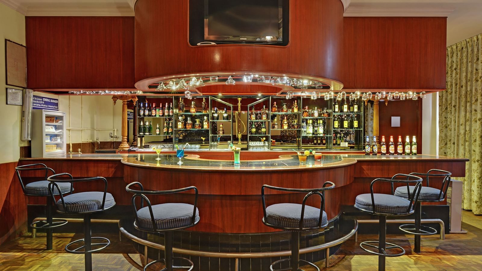 Bar with chairs around the counter at Hotel SRM Trichy