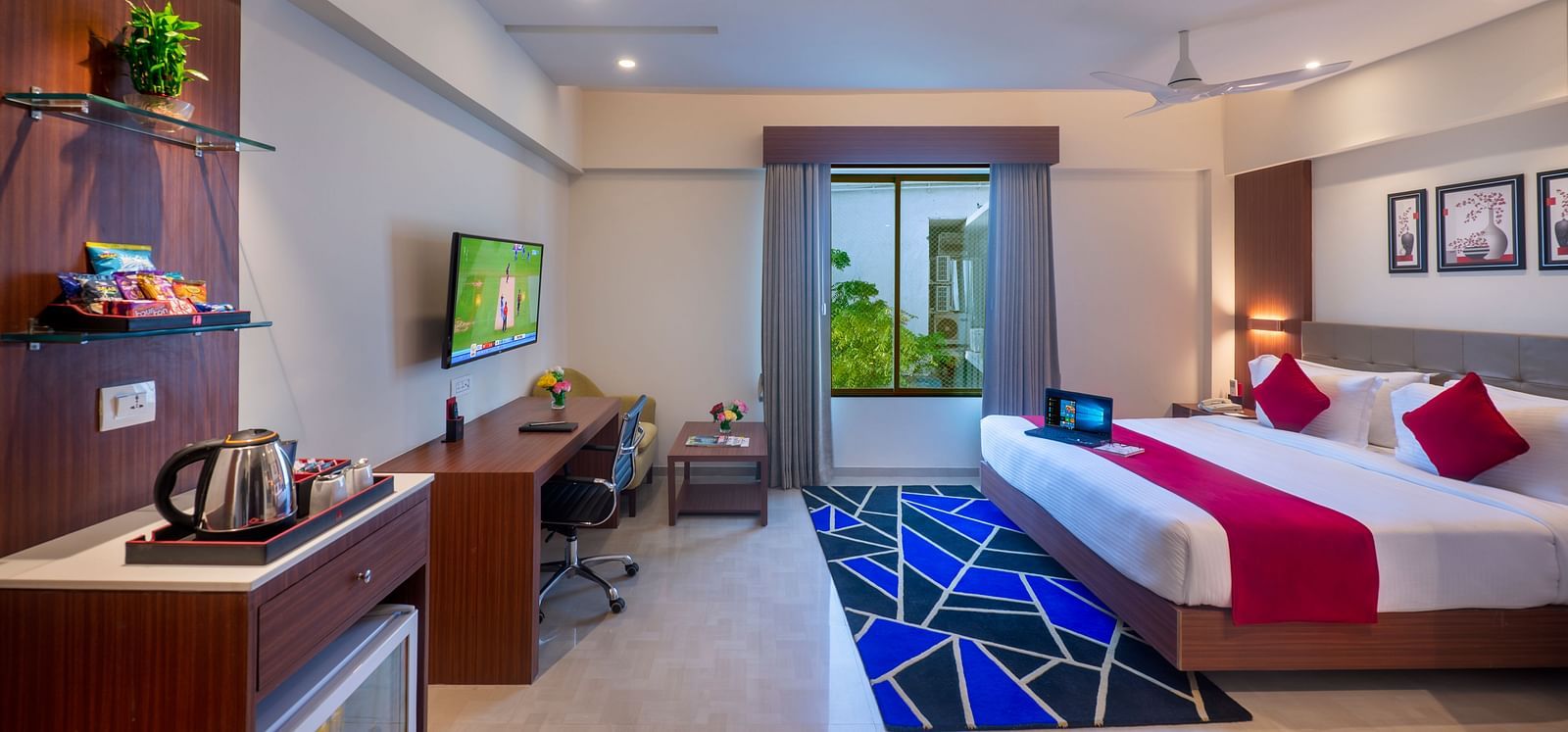 Double-bed room with entertainment unit, study area, and balcony access.