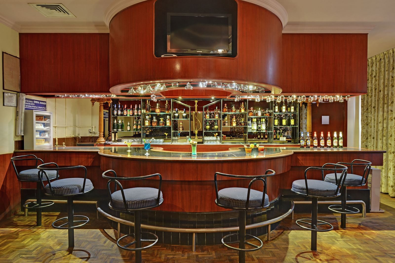 Bar with chairs around the counter at Hotel SRM Trichy