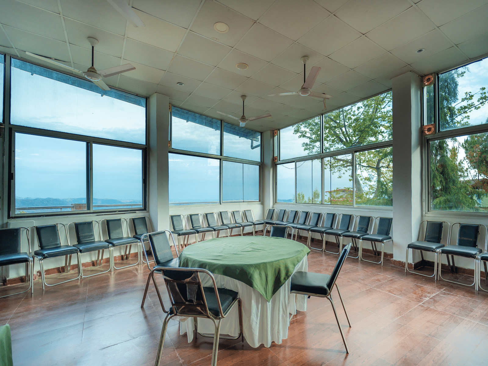 tables and chairs placed in the event venue at Flutter Hotels & Resorts surrounded by beautiful view of the valleys