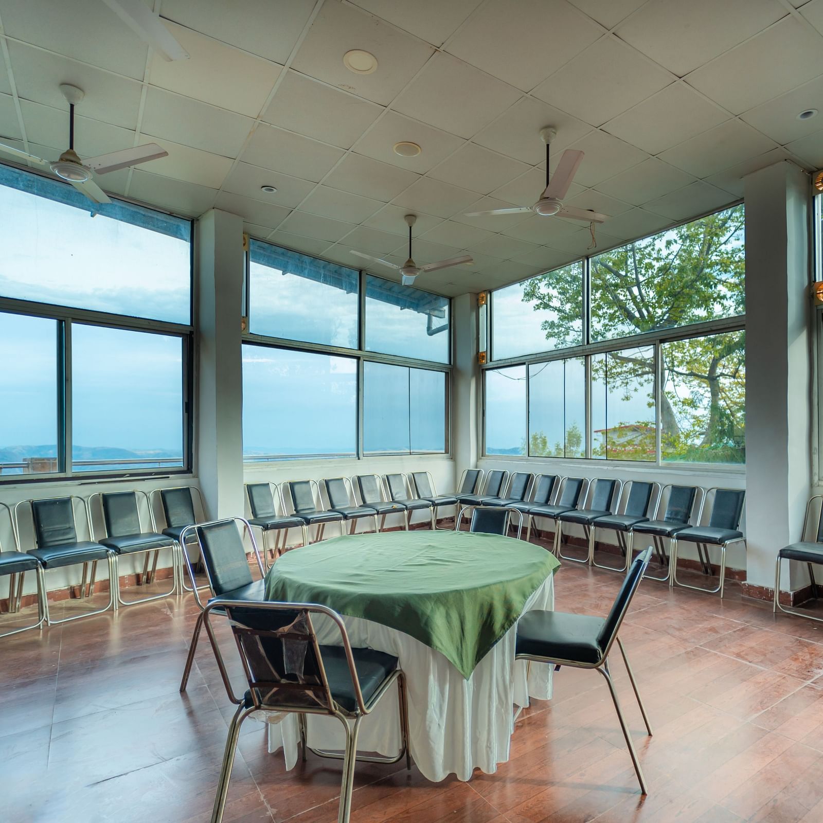 tables and chairs placed in the event venue at Flutter Hotels & Resorts surrounded by beautiful view of the valleys