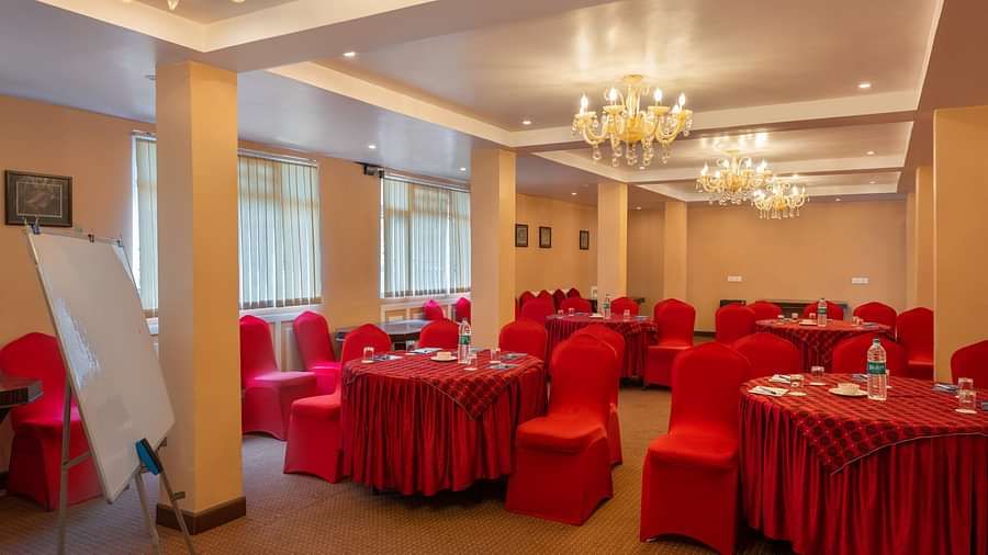 Multiple round tables and chairs placed in a closed hall that has chandeliers | Summit Oakden Resort & Spa, Mall Road