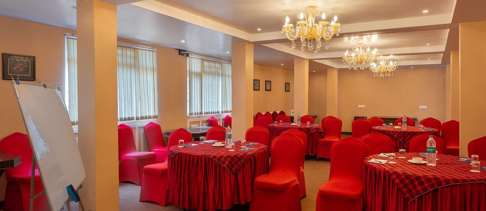 Multiple round tables and chairs placed in a closed hall that has chandeliers | Summit Oakden Resort & Spa, Mall Road