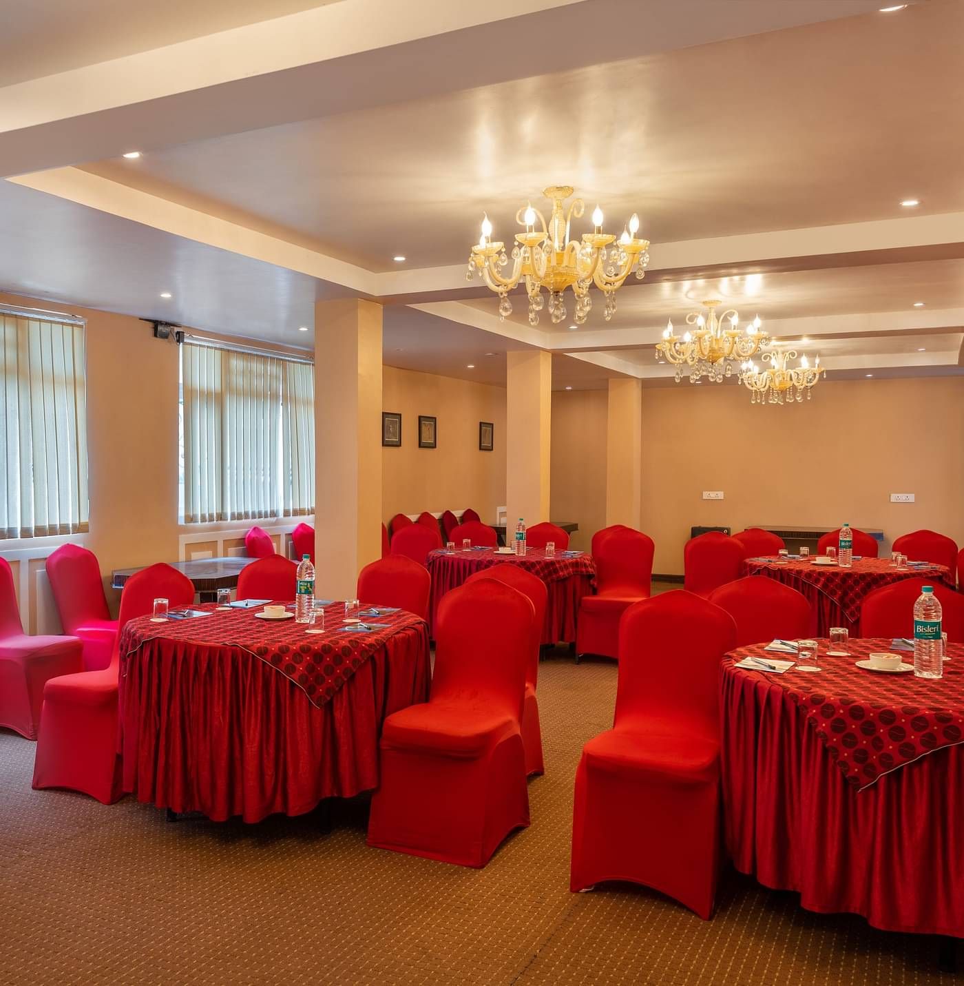 Multiple round tables and chairs placed in a closed hall that has chandeliers | Summit Oakden Resort & Spa, Mall Road