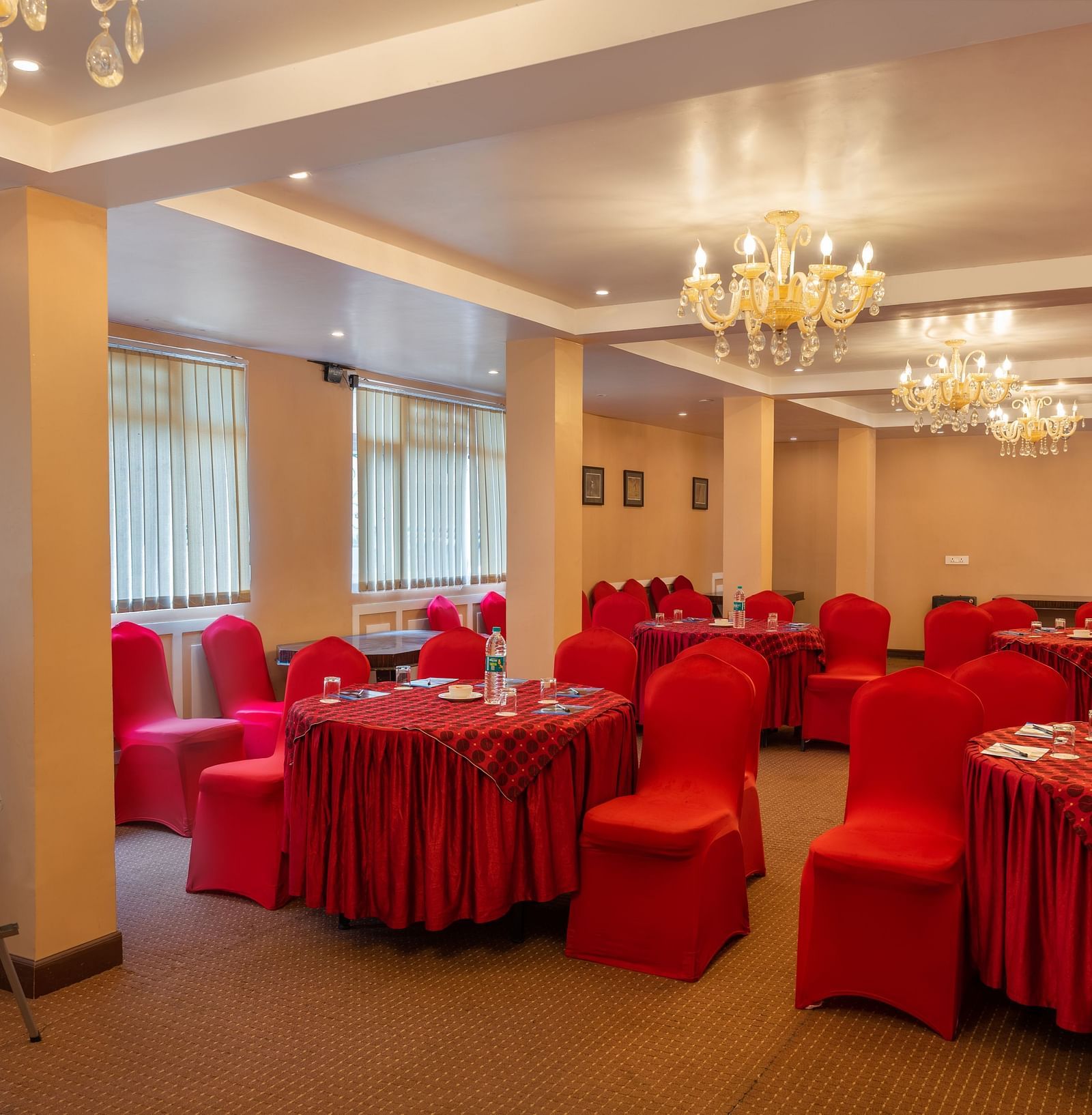 Multiple round tables and chairs placed in a closed hall that has chandeliers | Summit Oakden Resort & Spa, Mall Road