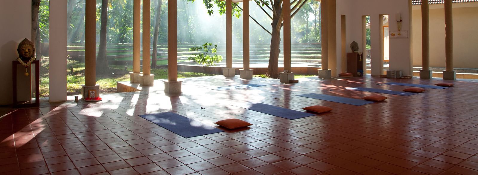 Indoor yoga studio with mats and large windows, natural light - Shreyas Retreat
