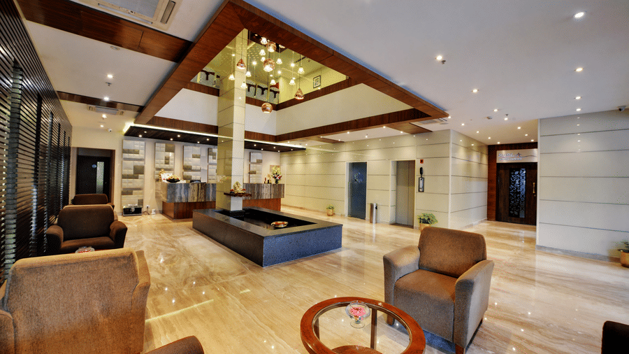 A hotel lobby with modern seating and a unique angled ceiling design.