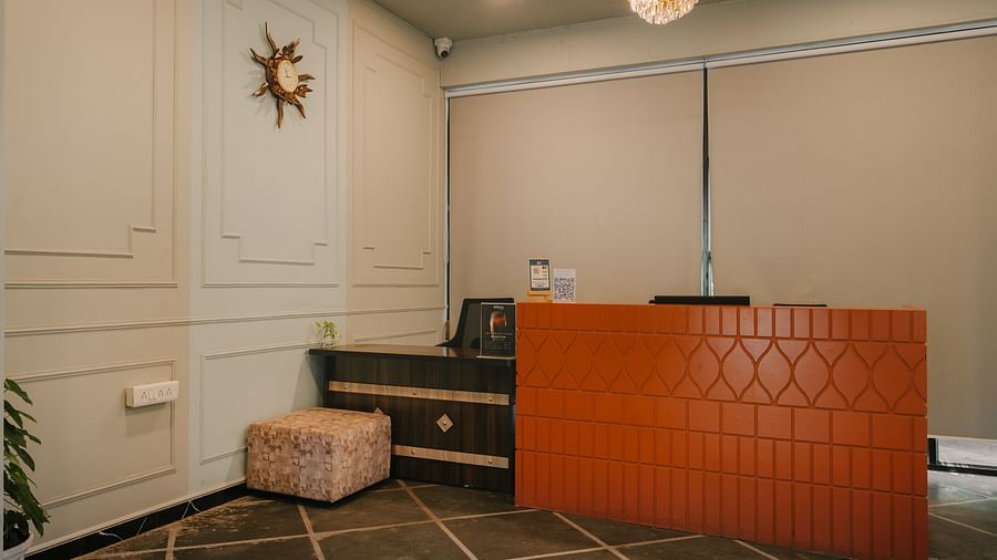 Reception desk at Richmonde Ananta Elite, Goa showcasing a stylish counter with modern orange-toned decor.