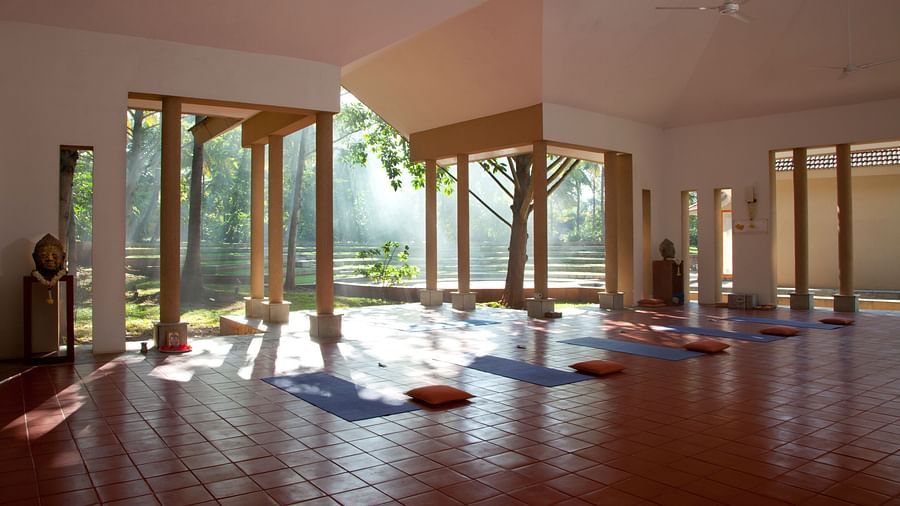 Indoor yoga studio with mats and large windows, natural light - Shreyas Retreat