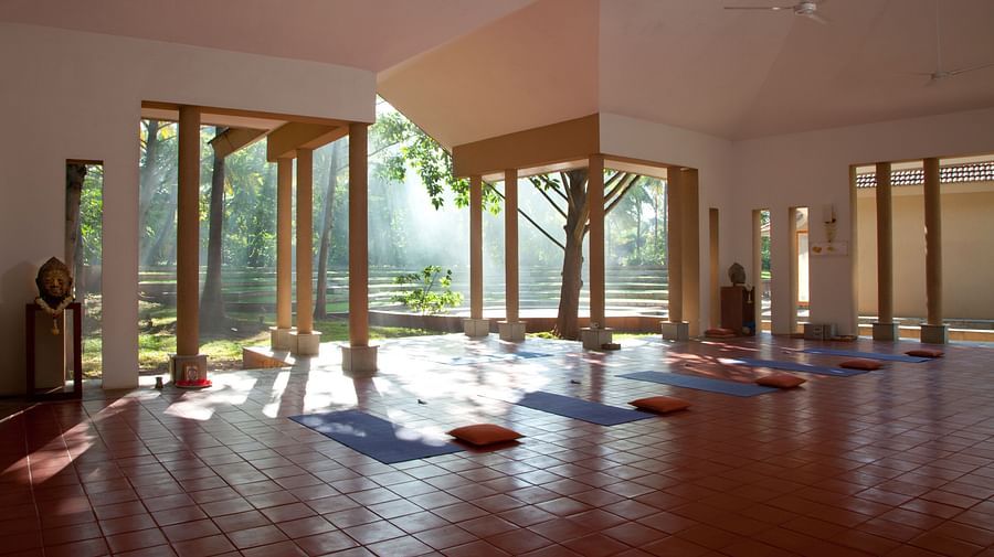 Indoor yoga studio with mats and large windows, natural light - Shreyas Retreat
