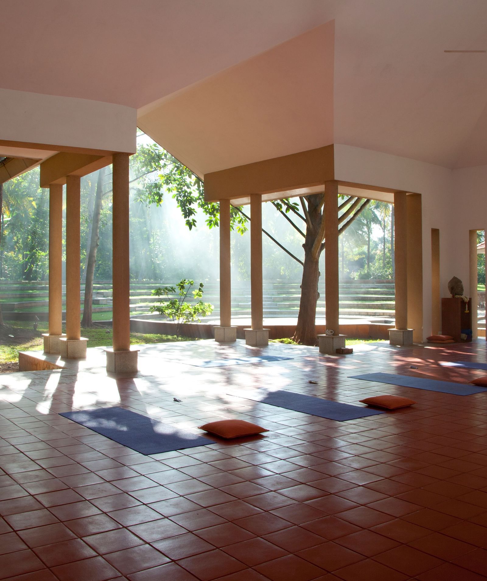 Indoor yoga studio with mats and large windows, natural light - Shreyas Retreat