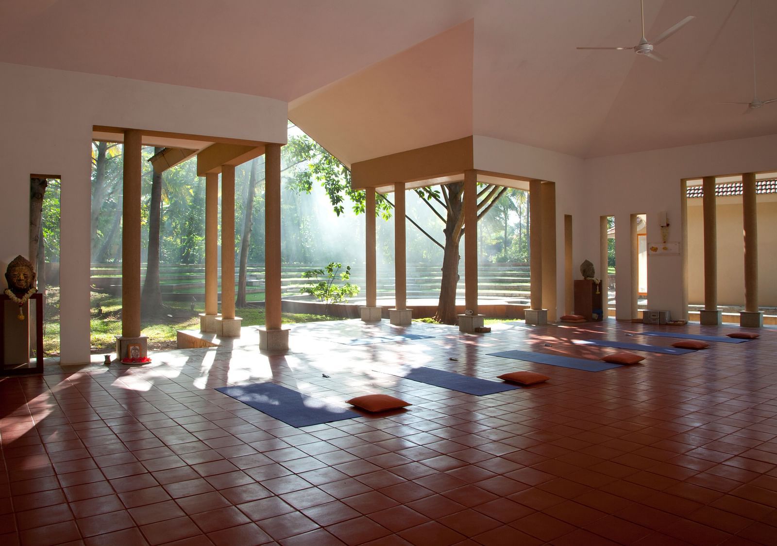 Indoor yoga studio with mats and large windows, natural light - Shreyas Retreat