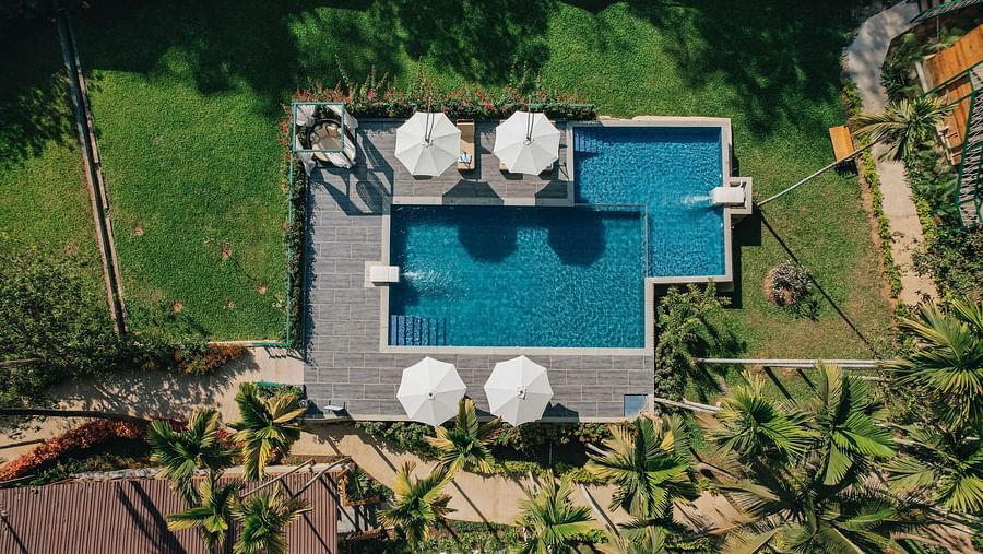 aerial view of the swimming pool with canopies open and garden surrounding it - Stone Wood Jungle Resort, Dandeli