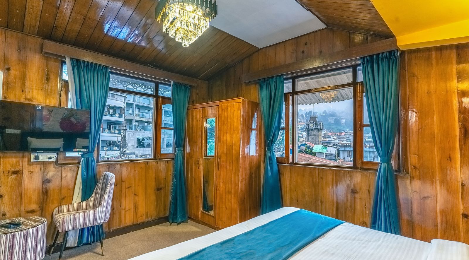The premium room offers views of the clock tower through its windows, along with warm lighting at Avianna Seven Seas, Darjeeling2