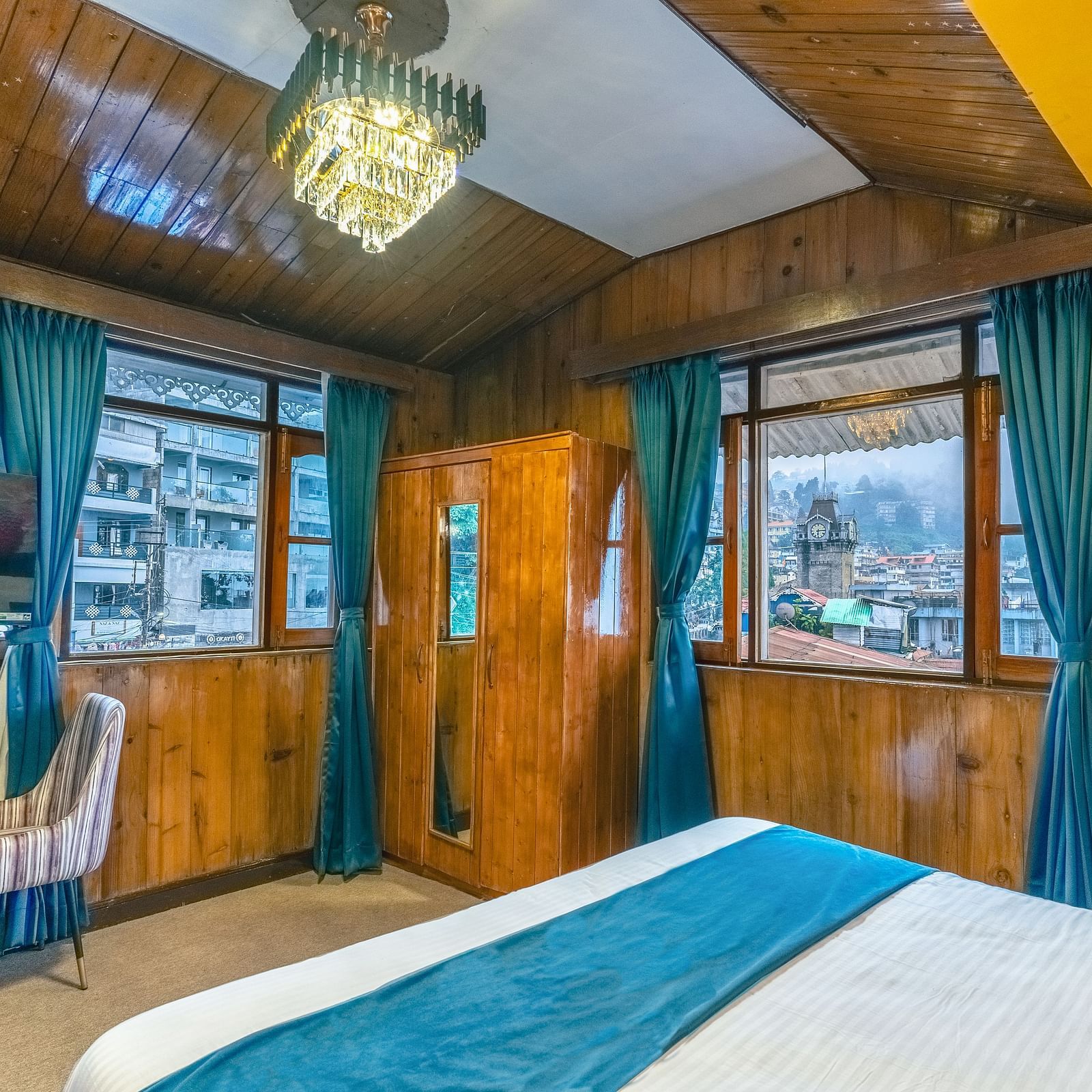 The premium room offers views of the clock tower through its windows, along with warm lighting at Avianna Seven Seas, Darjeeling2