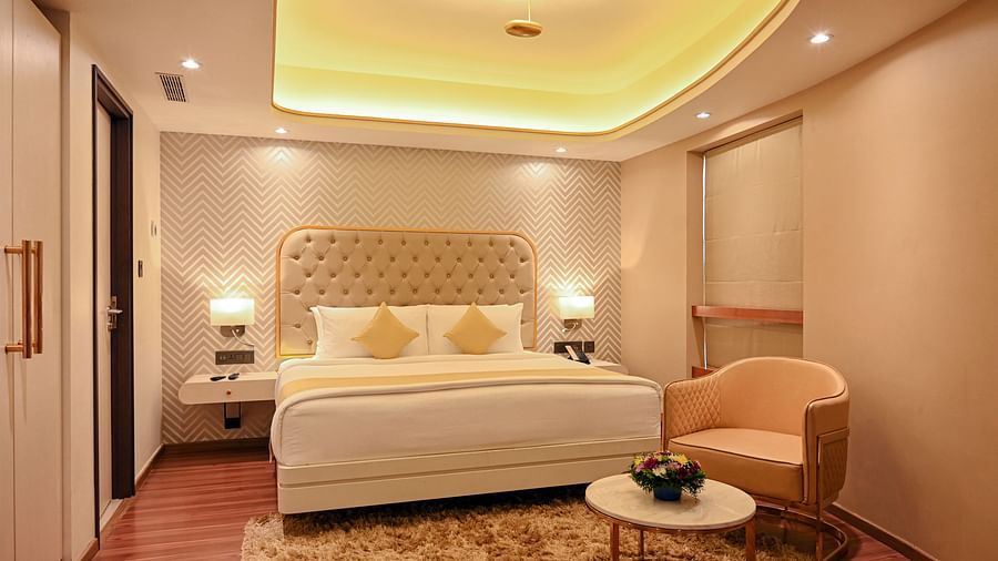 the king size bed with a sofa offered at a suite in Calicut