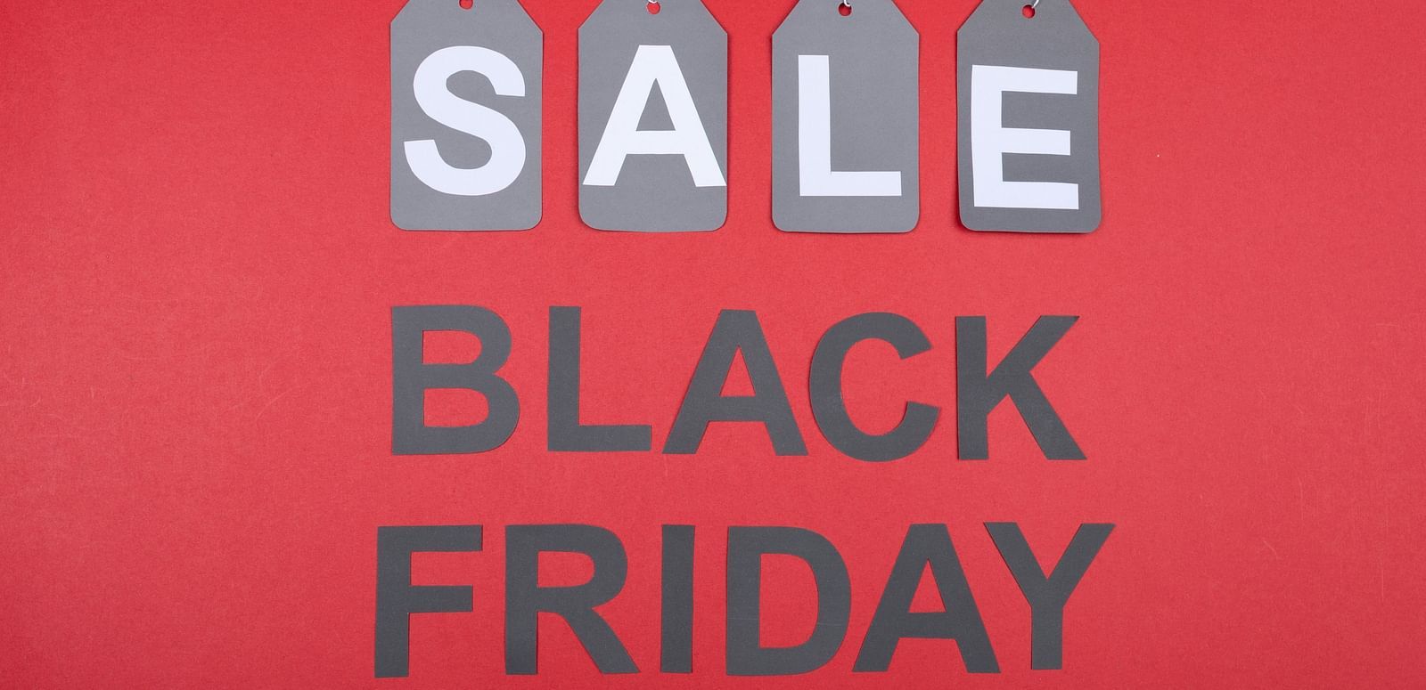 Bright red Black Friday sale sign with bold white text and hanging tags.