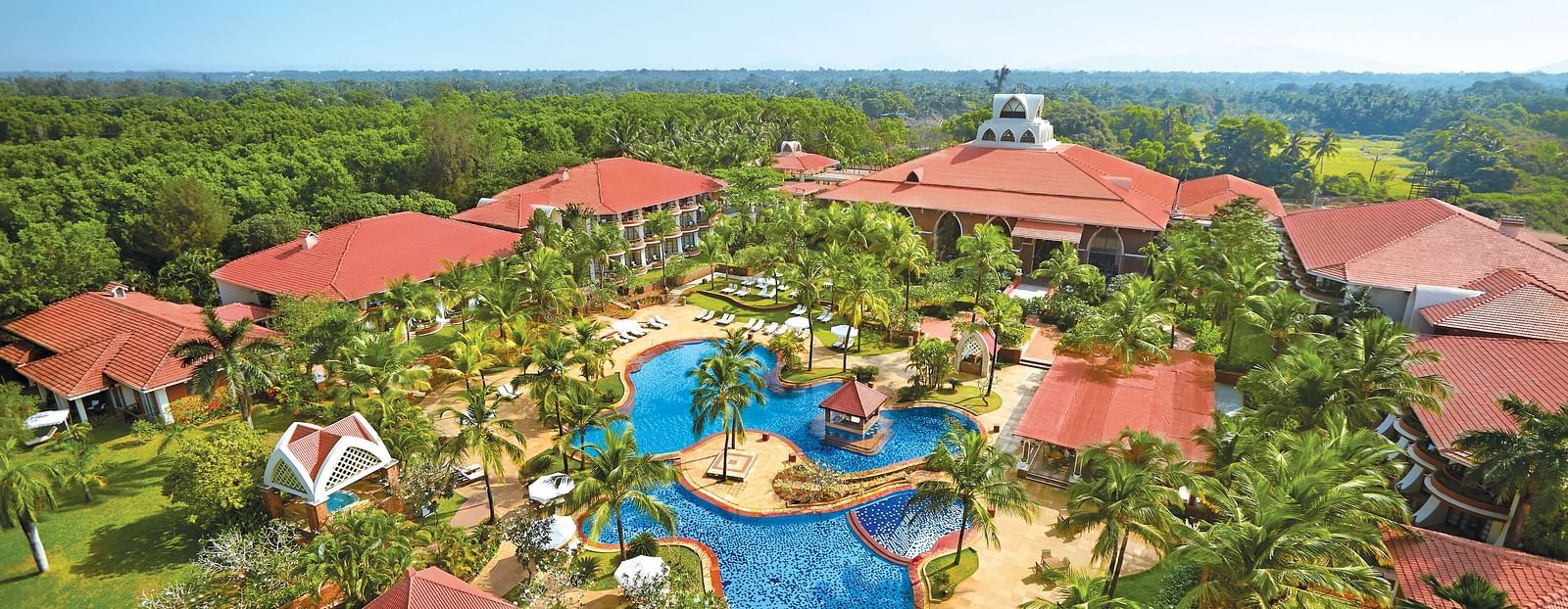 aerial view of Caravela Beach Resort Goa with forest cover in the background