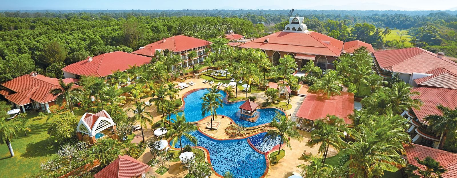 aerial view of Caravela Beach Resort Goa with forest cover in the background