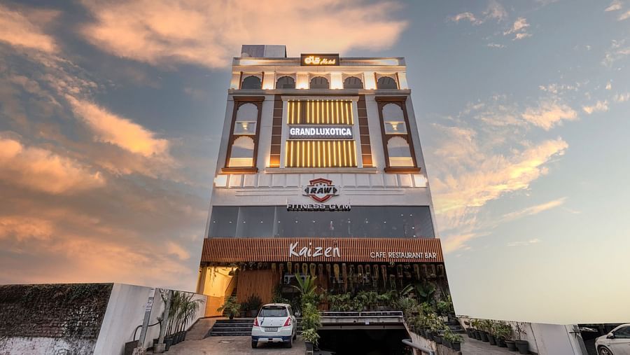 Facade of DLS Grand Luxotica, Dehradun lit up under the vibrant evening sky