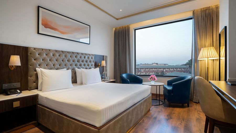 Modern hotel room with a minimalist design and natural light - Clarks Inn, Dehradun