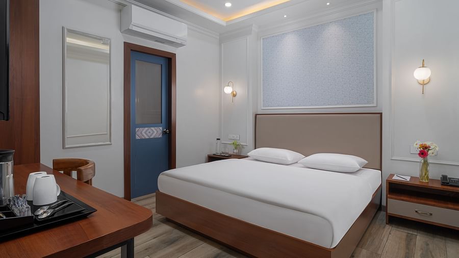 A spacious room with a large bed, wooden bedside tables on both sides, and inviting lighting | Hotel Ganga Maiya