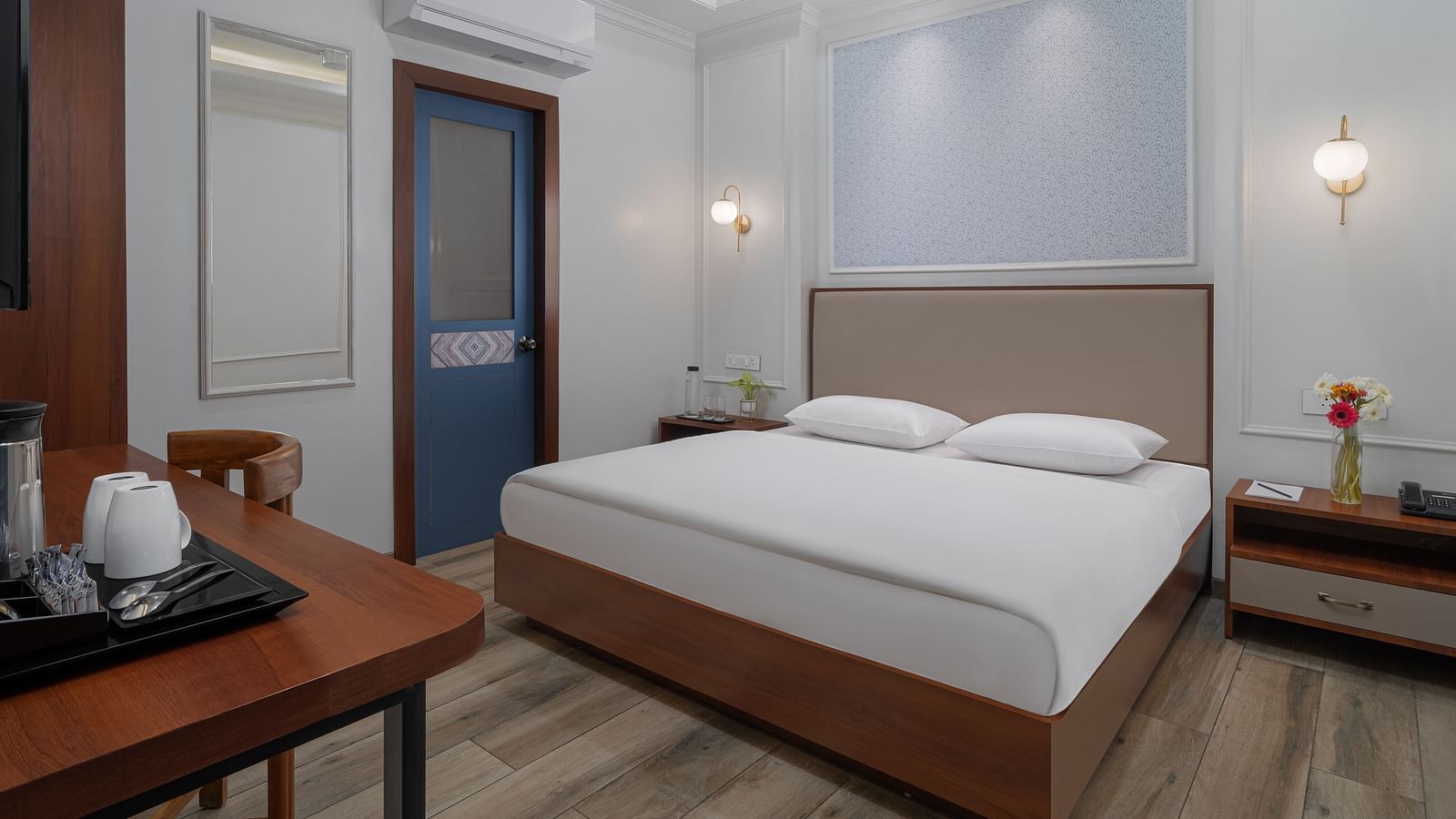 A spacious room with a large bed, wooden bedside tables on both sides, and inviting lighting | Hotel Ganga Maiya
