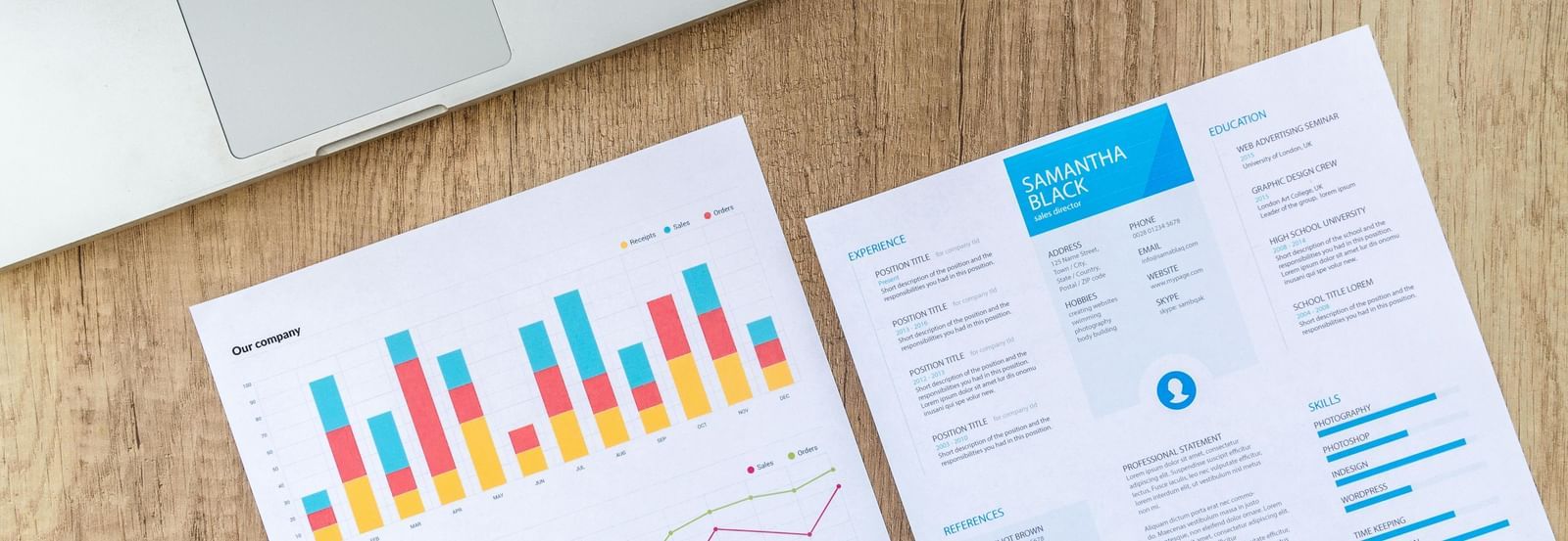 A laptop and two documents with charts and text on a wooden desk | Hiring Services