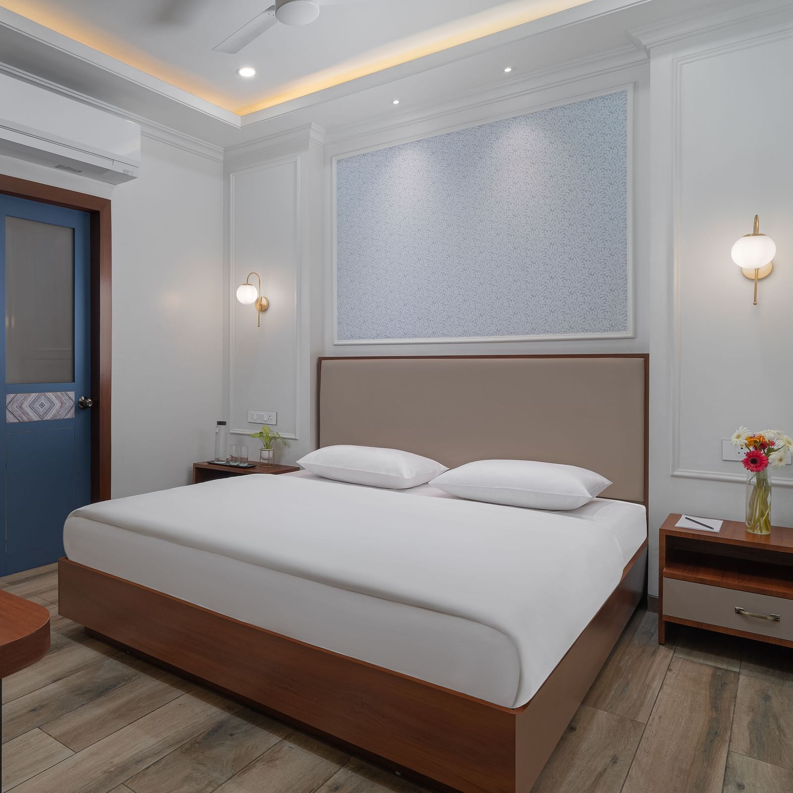 A spacious room with a large bed, wooden bedside tables on both sides, and inviting lighting | Hotel Ganga Maiya