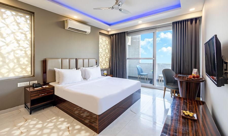 Luxury hotel room with a king size bed, modern interiors, and ambient lighting at Hotel Bawa, Gurgaon.