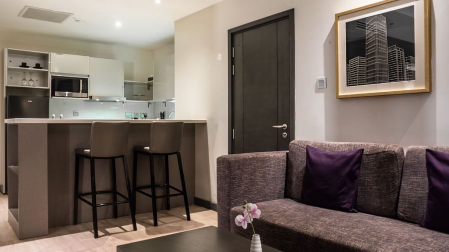 Modern suite at Best Western Premier Westlands hotel with a kitchenette, bar stools, and comfortable seating area, decorated in sophisticated tones