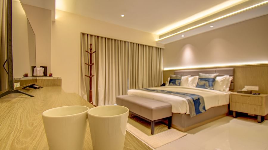 A hotel room with a bed, a plant, and a view of the bathroom - The SSK Solitaire Boutique Hotel & Spa, Gangapur Road - Nashik