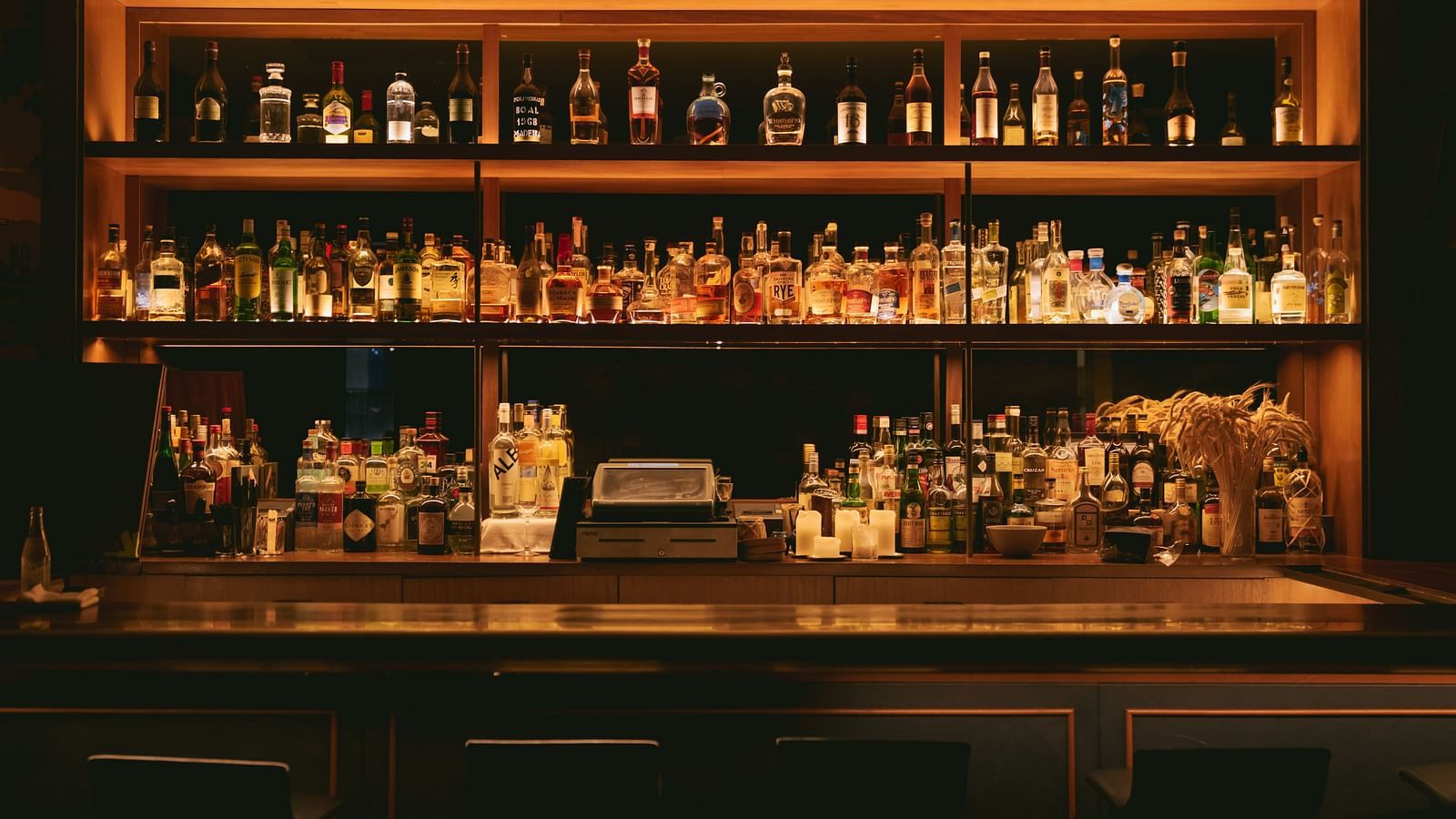 a brown wooden showcase with many bottles in it