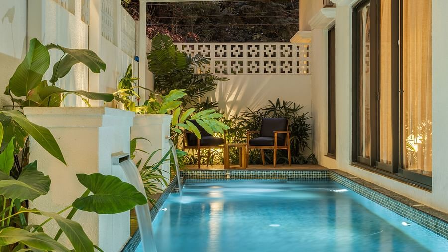 A view of a tranquil pool surrounded by plants, with sunlight streaming through a partially covered canopy - BluSalzz Villas - Alocassia, Anjuna