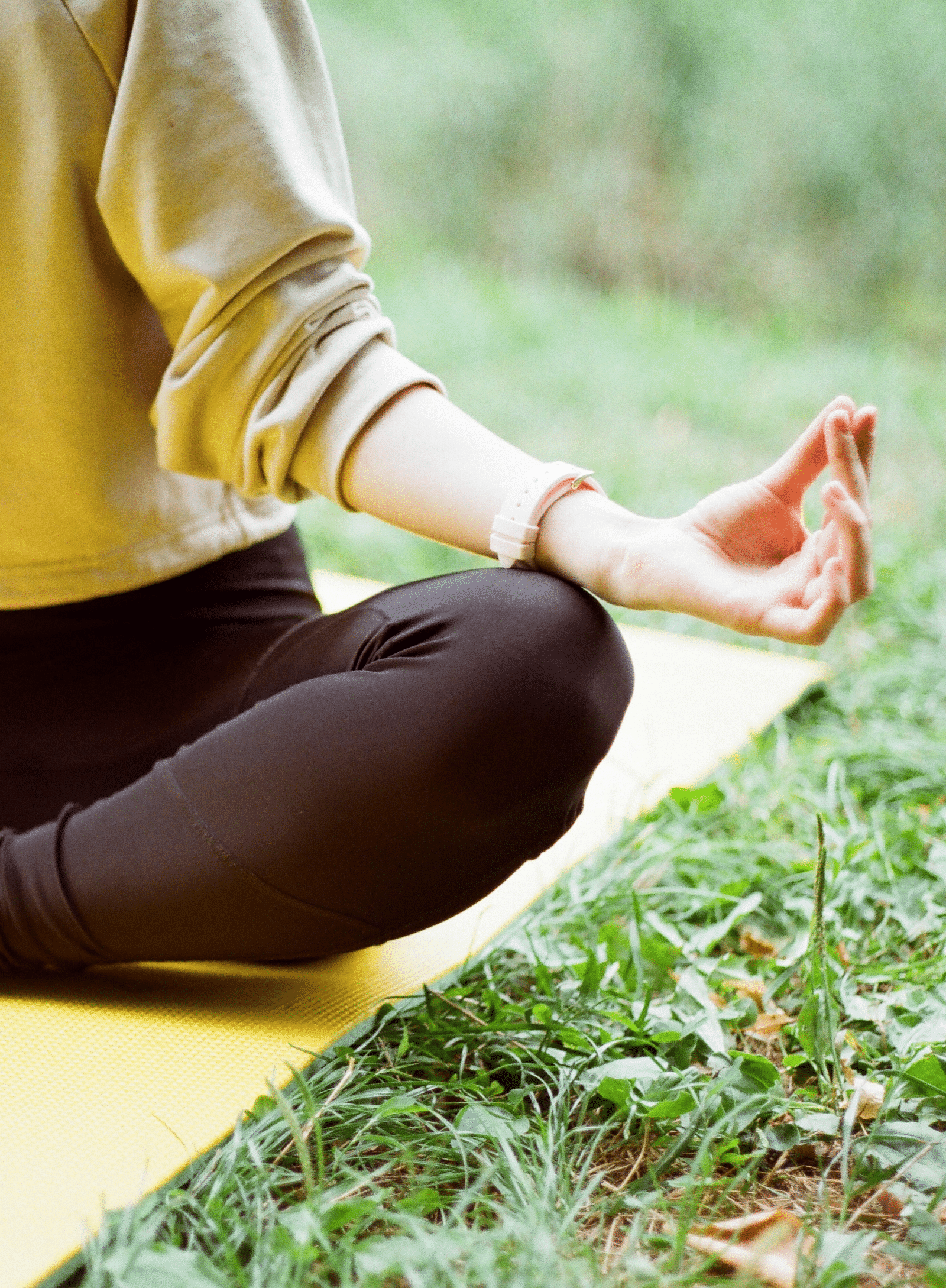 a person doing yoga on a grassy field during daytime