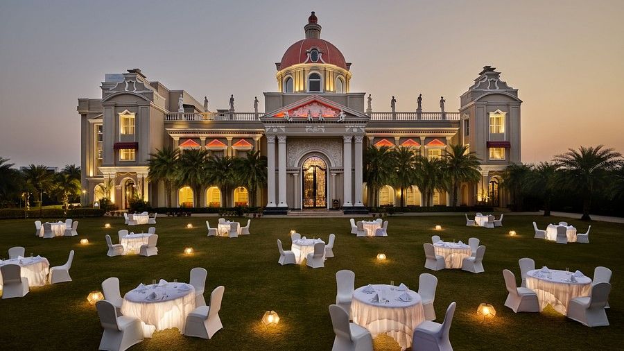 tables set up in cluster arrangement in the lawn at dusk - Royal Kingdom Sarovar Portico, Pilibhit