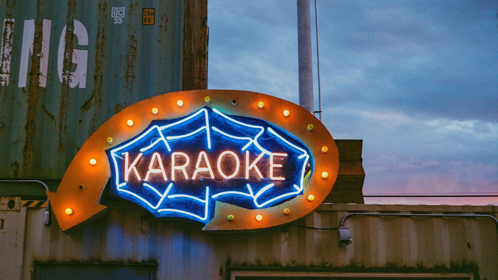 A LED board with the letter Karaoke written on it and a spider web covering the letters