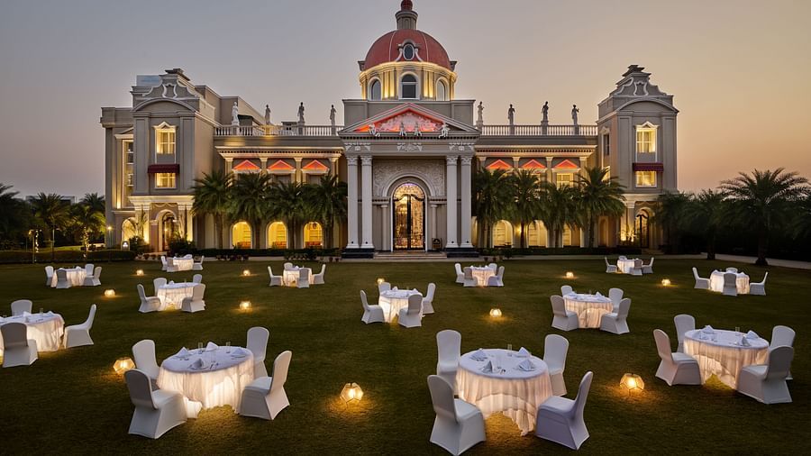 tables set up in cluster arrangement in the lawn at dusk - Royal Kingdom Sarovar Portico, Pilibhit