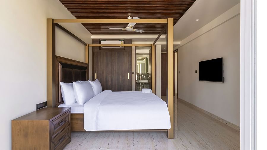 A double bed with wooden beams inside one of the rooms - The Tanisi Hotels & Resorts, Goa