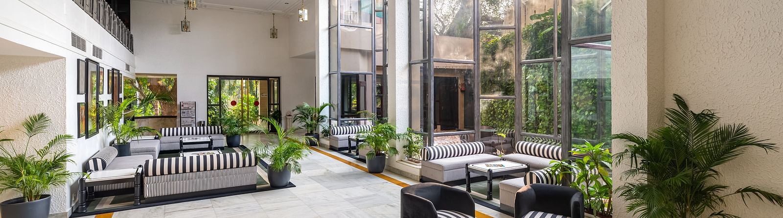 An overview of the lobby of our hotel in Udaipur with seating arrangements and plants in view - Hotel Rajdarshan, Udaipur.